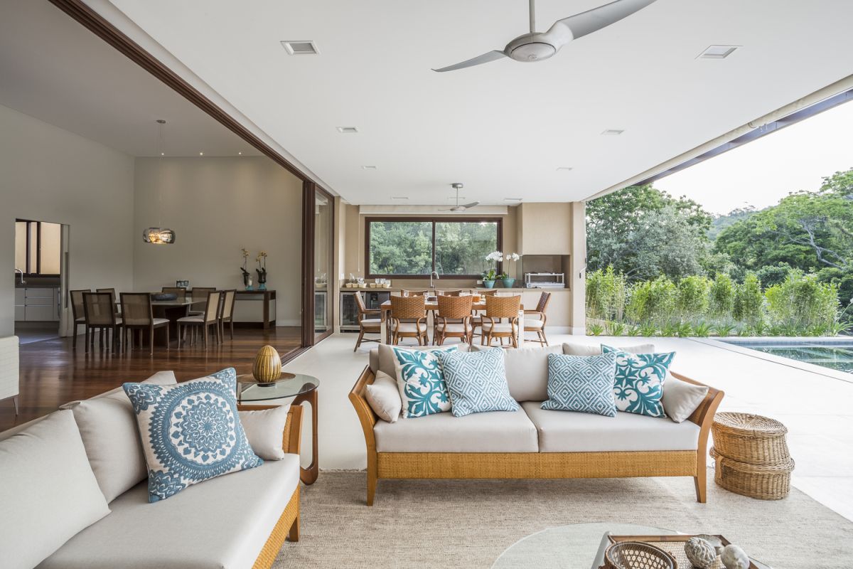 The poolside deck and adjacent area are treated as seamless extensions of the indoor living room