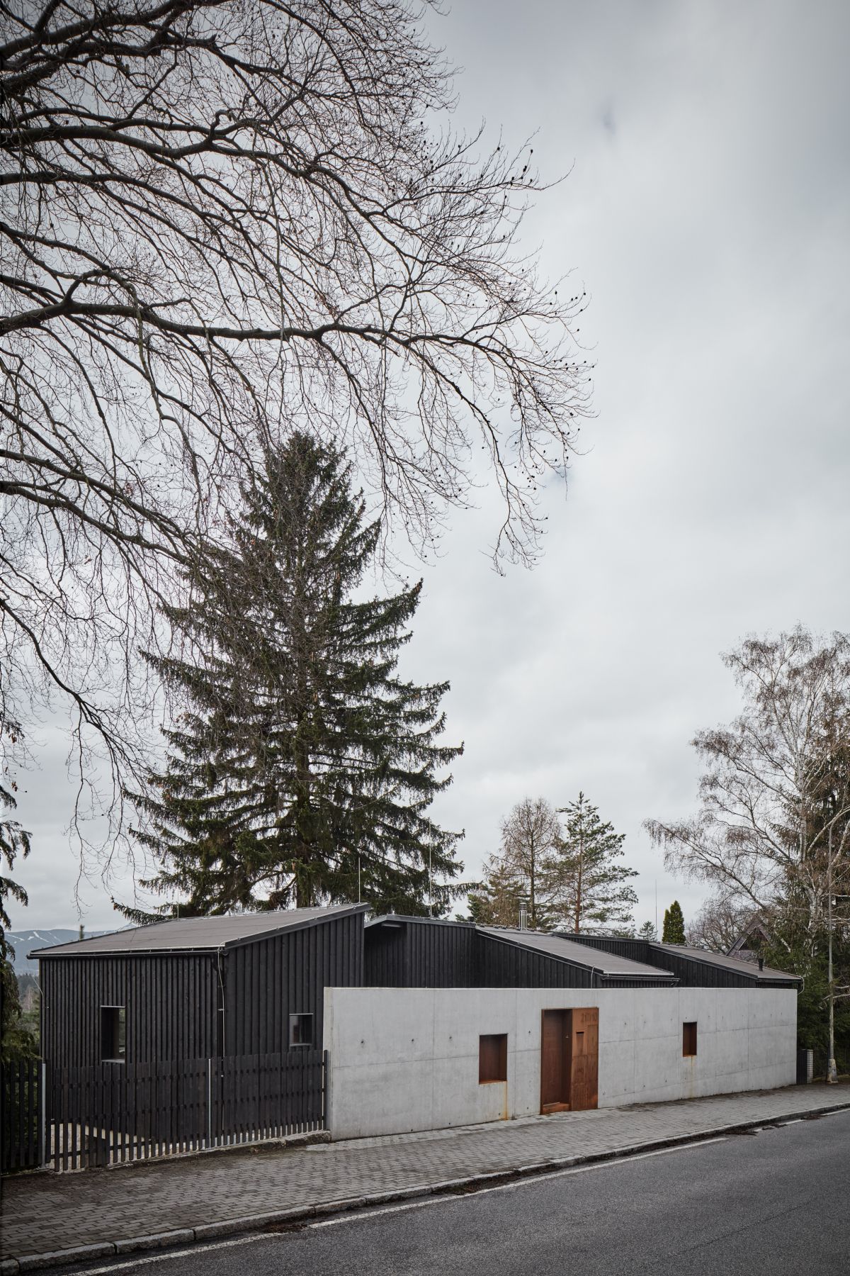 A concrete wall acts as a shield between the house and the road which borders it