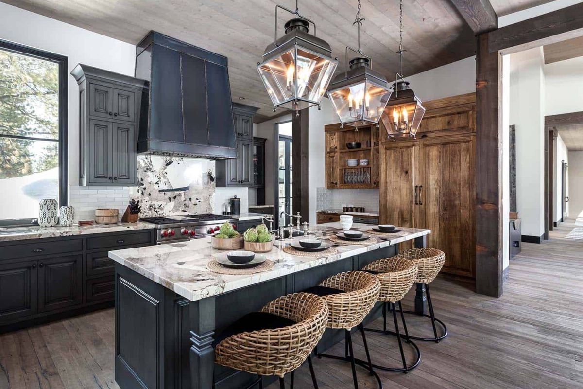 The kitchen island is complemented by four comfy basket chairs and rustic lantern pendant lamps