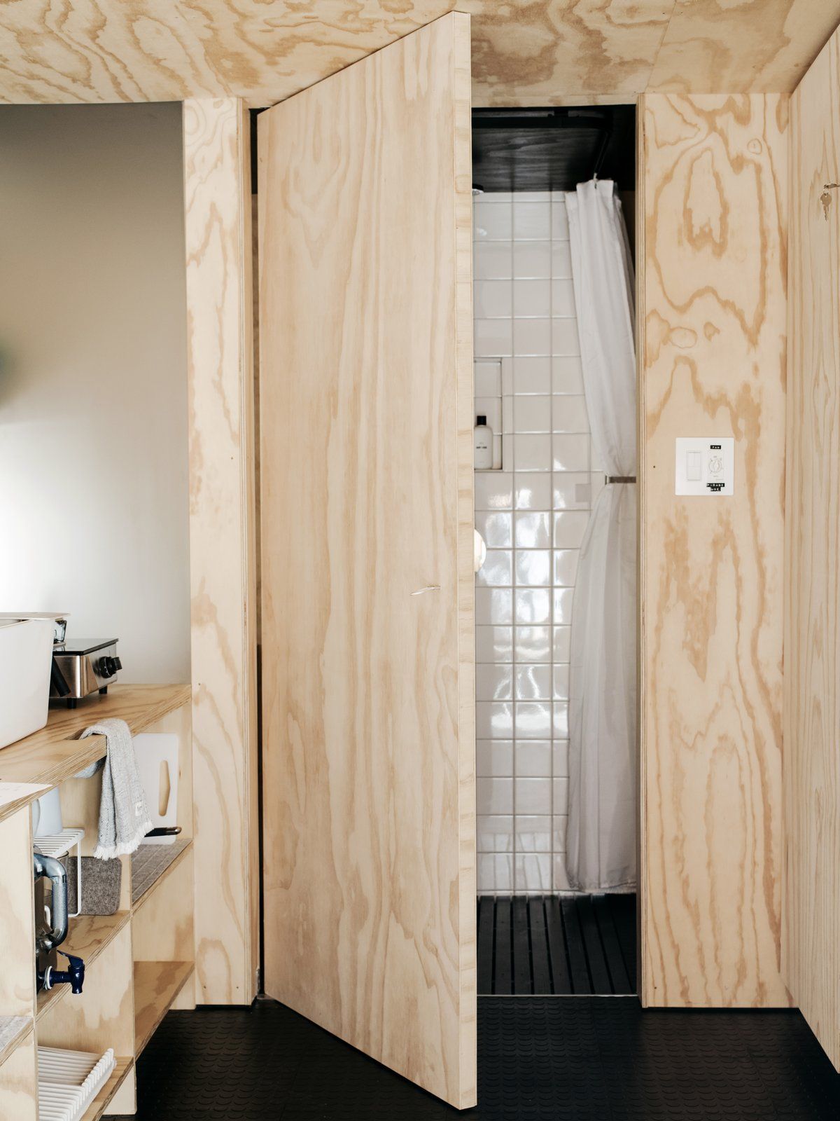 A tiny bathroom is situated next to the kitchen and features a frosted glass wall which lets light pass through