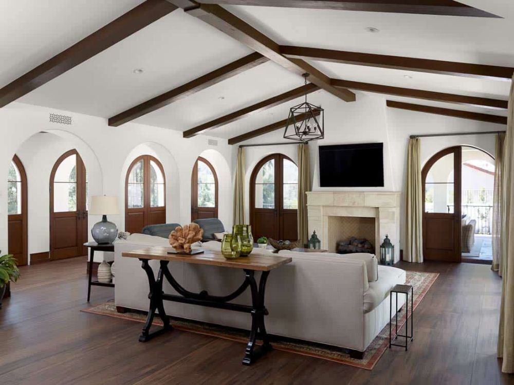 The living room has white walls, a white ceiling and a beautiful dark wood floor