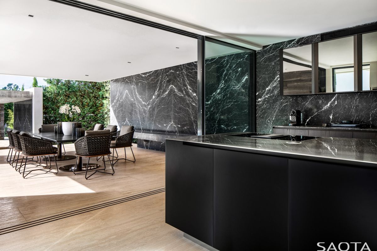 Black marble surfaces add elegance to the interior design and establish a harmonious connection with the wooden flooring