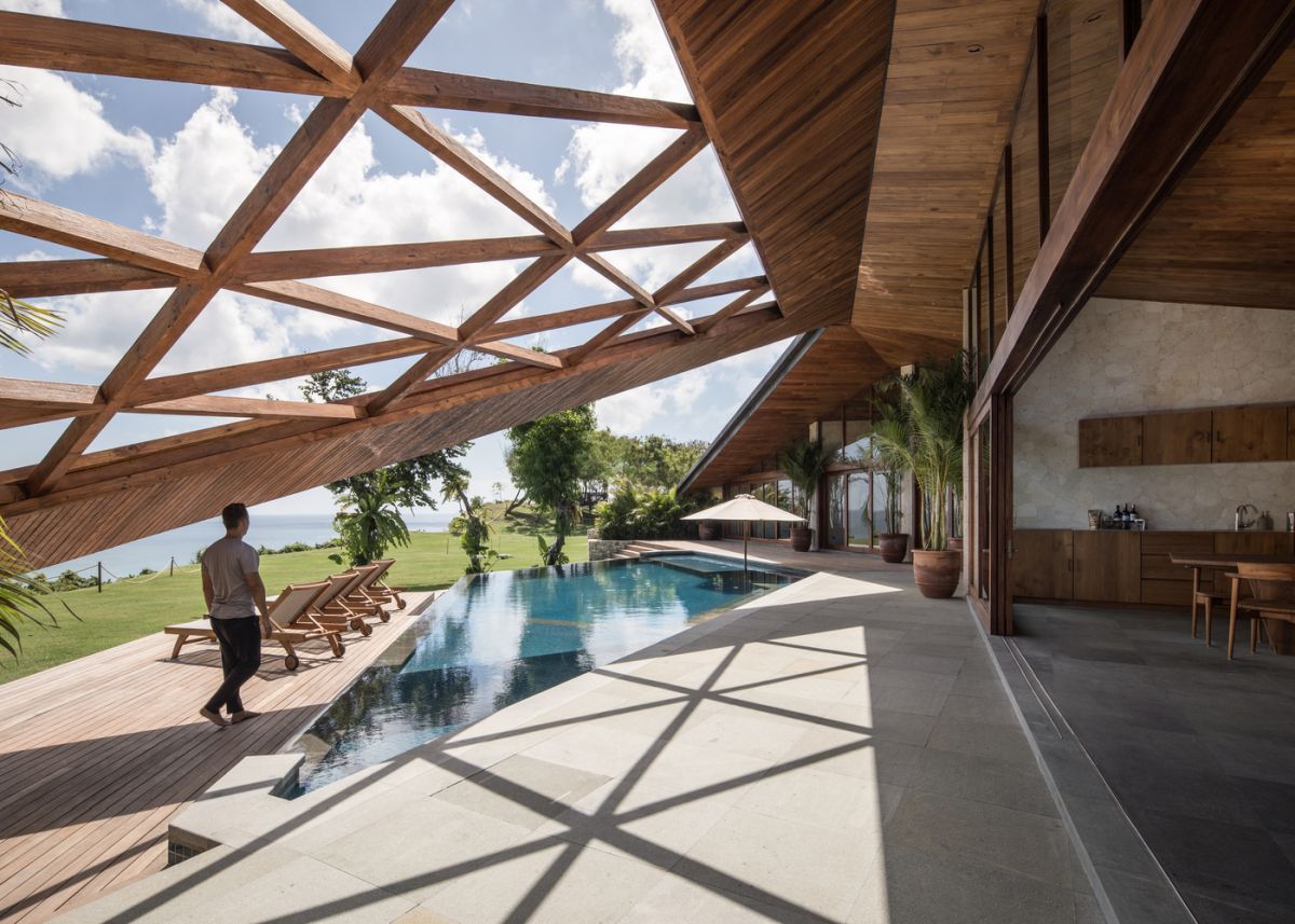 The roof extends over the poolside area, forming an unusual decorative cover