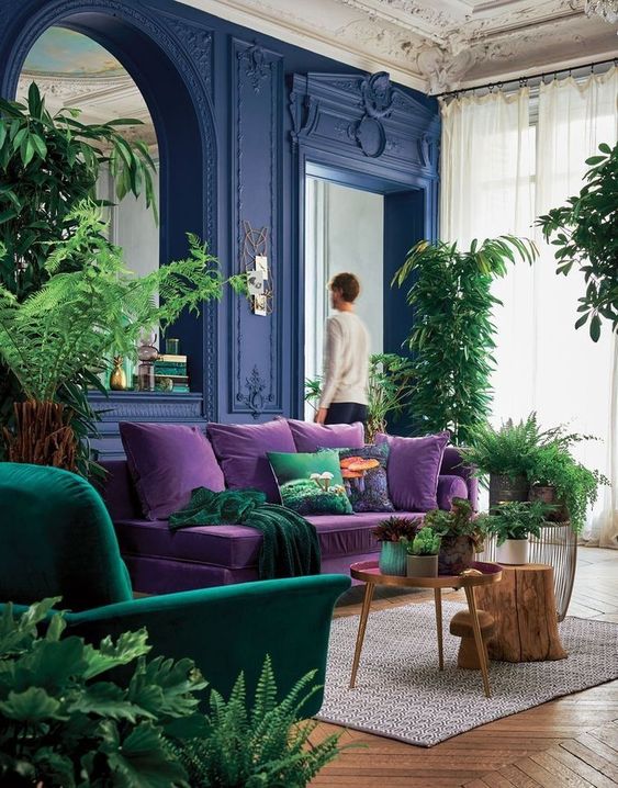 living room with velvet purse sofa and green armchair