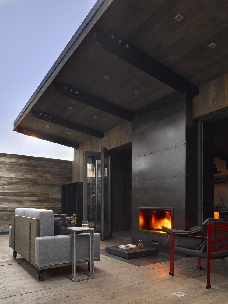 The fireplace is double-sided and the roof overhang creates a cozy protected area outside